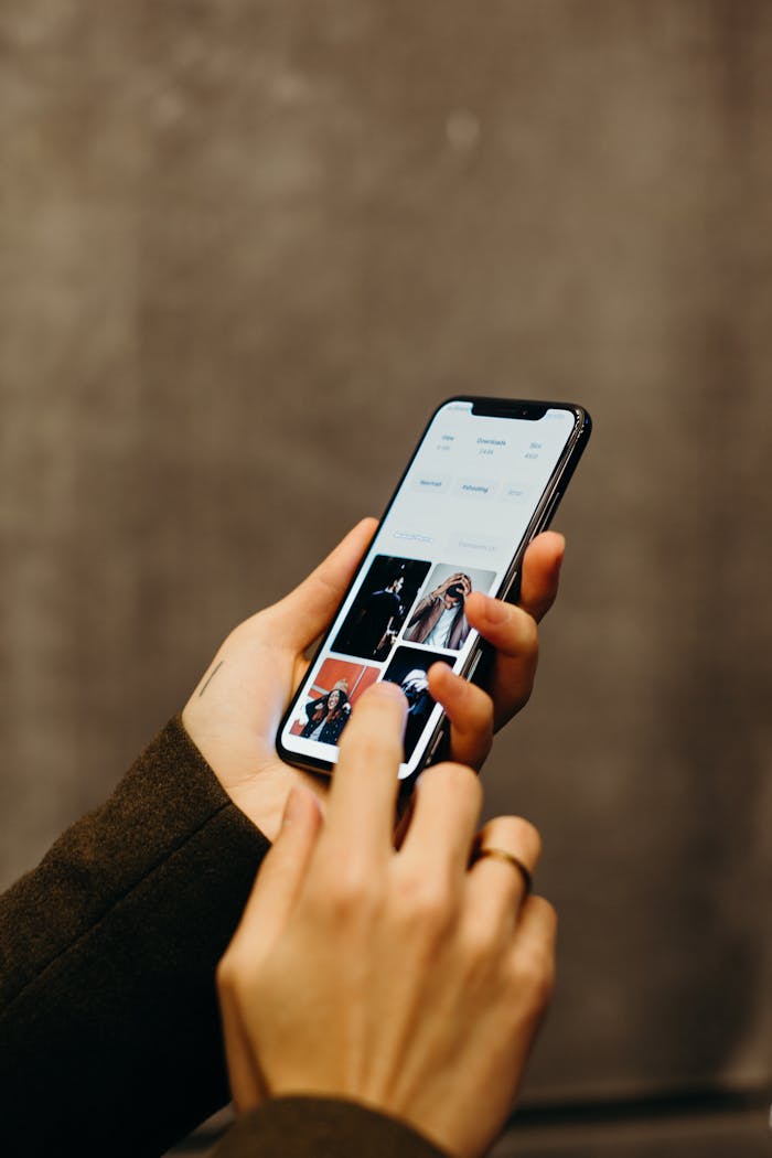 About Close-up of hands using a smartphone to browse a photo gallery app, showcasing modern technology.